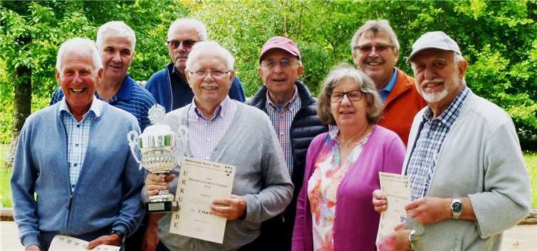Die Vorsitzende des Bürgervereins Elke Heiß stellte den Clubmeister 2019 Reinhard Heiß (mit Pokal), den Zweitplatzierten Ulli Burkholz (rechts) sowie Jürgen Braun auf Platz drei (links) im Beisein der Runden-Teilnehmer vor.Foto: Ulli Burkholz