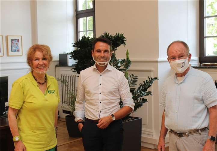 Die Vorsitzende des Vereins für besseres Hören, Treffpunkt Ohr e.V. Brigitte Hilgert-Becker (links im Bild) hat gemeinsam mit den stellv. Behindertenbeauftragten der Stadt Koblenz Joachim Seuling (rechts) eine Mund-Nase-Bedeckung aus Plexiglas an den Koblenzer Oberbürgermeister David Langner übergeben.Foto: Stadt Koblenz