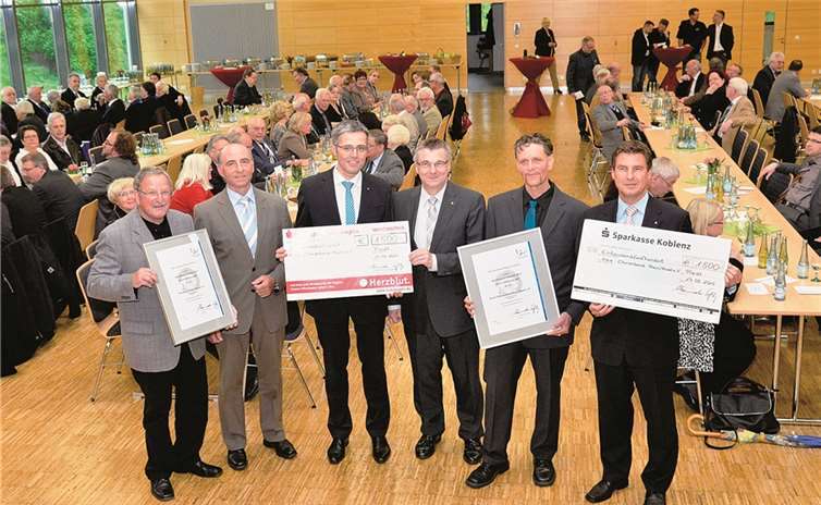 Die Vorsitzenden der Kreis-Chorverbände, Peter Weiler (l., Mayen) und Joachim Rünz (2.v.r., Rhein-Mosel) freuen sich über Auszeichnungen und Preisgelder, die Kreisbeigeordneter Rudi Zenz, Karl-Josef Esch (Vorstandsmitglied der Kreissparkasse Mayen), Landrat Dr. Alexander Saftig und Matthias Nester (Vorstandsvorsitzender der Sparkasse Koblenz) überreichten (v.l.n.r.). privat