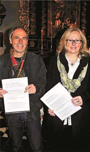 Die Vorsitzenden der beiden Gremien Gero Nölken (ev.) und Christa Langen (kath.) mit den unterzeichneten Urkunden.