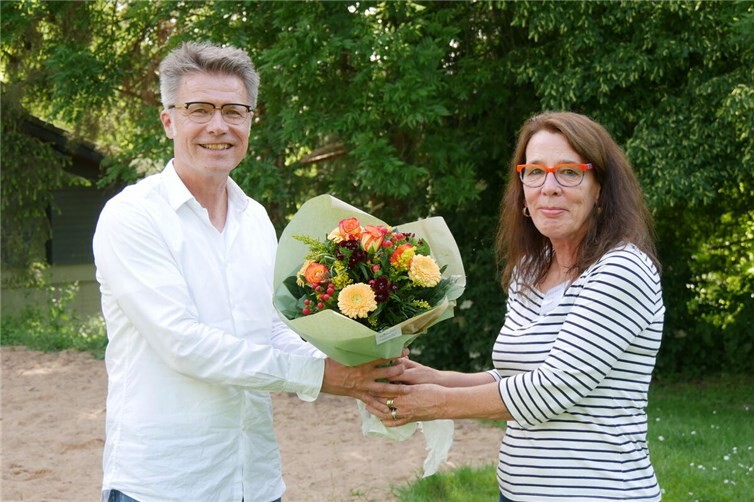 Die Vorstandsvorsitzende von EIRENE e.V. Martina Richard begrüßt den neuen Geschäftsführer Guido Dost in seinem Amt mit Blumen.