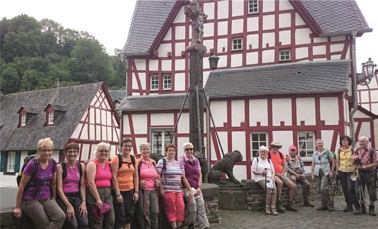 Die Wandergruppe des Andernacher Eifelvereins am Löwendenkmal auf der Monrealer Nepomukbrücke. Im Hintergrund befindet sich das Viergiebelhaus aus dem Jahre 1452.  privat