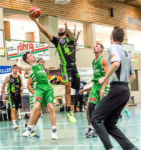 Die beiden Top-Scorer ihrer Teams in Aktion: Der Treis-Kardener Biddle bei einem erfolgreichen Korbleger. Rechts daneben in grün der Nieder-Olmer Nap (Nummer 21).  Foto: Lisa Ferrlein.