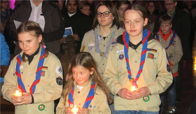 Die brennenden Kerzen werden in den Dom getragen.