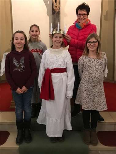 Die diesjährige Lucia-Darstellerin Lena Baum erhielt die Lichterkrone aus der Hand der Messdienerbetreuerin Andrea Wittkopf überreicht. Mit dabei waren Anna und Frieda Gies sowie Anika Faßbender, die zusammen als Gefährtinnen die „Lucia“ in der Prozession begleiten.Foto: privat