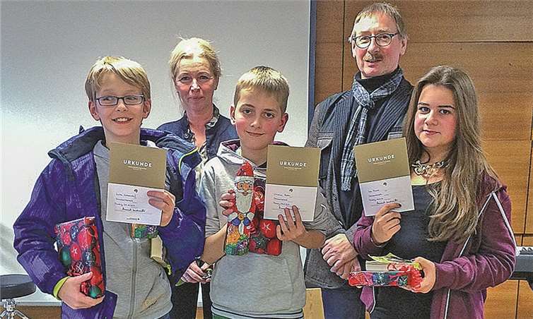 Die drei strahlenden Sieger (v.l.) Luka Wiesendorf (2. Platz), Christian Raben (1. Platz) und Lea Munk (3. Platz). Im Hintergrund Frau Kohlhass und Herr Waldecker, die sich seit Jahren für den Vorlesewettbewerb der Realschule plus und Fachoberschule Mendig einsetzen.privat