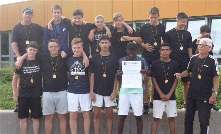 Die erfolgreiche Mannschaft mit den Goldmedaillen und Urkunden: (hintere Reihe v.l.n.r)Realschullehrer Harald Reif, Viktor Wagner, Shefqet Ramadani, Leon Kuppert, Tyler Schweda,Cedric Dölle, Denis Kuqi und Emilio Scherbarth; (vordere Reihe v.l.n.r.) Rene Rünz, Enrico Auras,Lukas Schui, Pejman Mirzaj, Marcel Kreller, Mouhammad Alabed und Trainer Peter Reif. Foto: privat