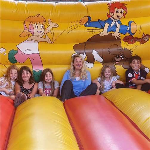 Die erste Vorsitzende Elke Bauer mit Vereinskindern auf der Hüpfburg.  Foto: Nina Jung