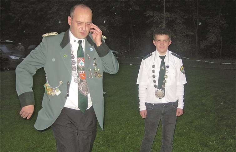 Die ersten telefonischen Glückwünsche treffen ein, als die Raubacher Markus Kohl (Schützenkönig, li) und Dominique Kolbe (Schützenprinz) auf dem Weg zum Foto-Termin für ein Gemeinschaftsfoto aller Teilnehmer sind.