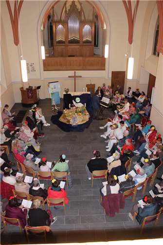 Die evangelische Kirche füllte sich mehr und mehr, alle ankommenden Frauen wurden begrüßt und erhielten eine Papierblume, die sie sich in ihr Haar steckten. Foto: Inge Gebel