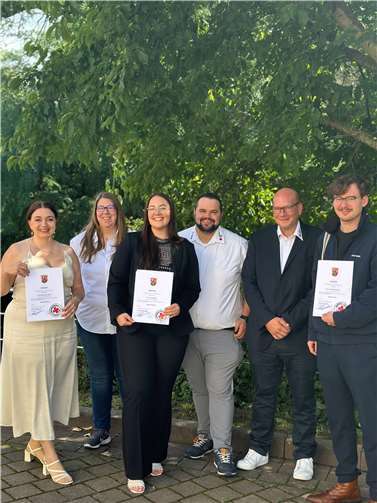 Die frischgebackenen Notfallsanitäterinnen und –sanitäter Doreen Bieber (li.), Antonia Müller (2. V. .li) und Maximilian Speer (re.) bekamen ihre Urkunden bei einer feierlichen Zeremonie in Mainz verliehen. Der stellvertretende DRK-Rettungsdienstleiter Boris Linden (2. v. re.), Praxisanleiterin Tanja Palm (2. v. li.) und Praxisanleiter Simon Barthel (4.v.li.) freuten sich für und mit ihren Schützlingen.  Foto: Mitch Walscheid / DRK-Kreisverband Ahrweiler e.V.