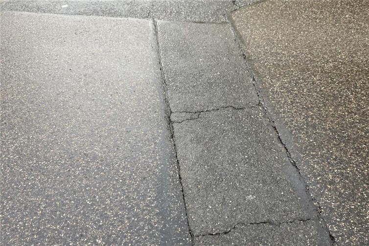 Die gebrochene und abgesackte Grabenoberfläche und der Hügel über dem Abwasserschacht 