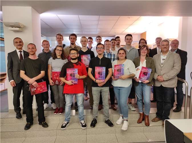 Die glücklichen Jung-Gesellen mit ihrem Freisprechungsbrief und den Ehrengästen umringen den Prüfungsbesten Pfau und die „Gute Form“-Gewinnerin Katharina Limbach (Mitte). Foto: Hans Hartenfels