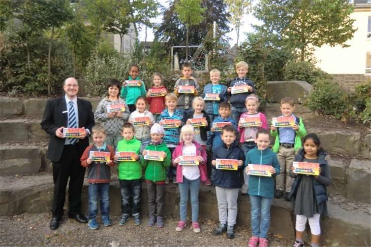 Die i-Dötzchen der Grundschule St. Martin in Remagen freuen sich gemeinsam mit Frank Kremer (l.), Leiter der Geschäftsstelle in Remagen, über ihre neuen Farbkästen von der Kreissparkasse Ahrweiler. privat