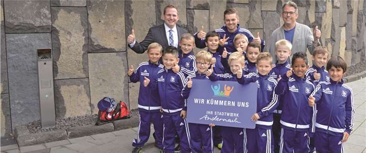 Die jungen Kicker des FC Andernach und ihr Trainer Christian Schopf (M.) bedankten sich bei den Spendern, Lars Hörnig (l.), Geschäftsführer Stadtwerke Andernach, und Christian Heller (r), Geschäftsführer Geysirzentrum Andernach), für die neuen Trainingsanzüge.privat