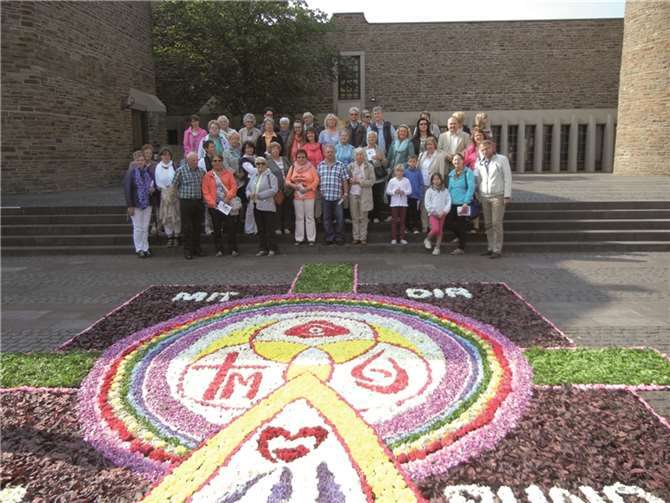 Die kfd-Gruppe vor einem Blütenteppich an der Anbetungskirche.privat
