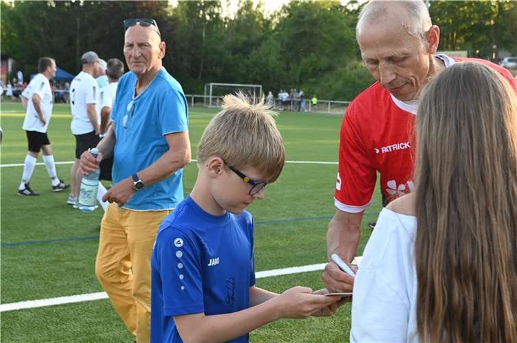 Die kleinen Autogrammjäger kamen auch bei Matthias Scherz auf ihre Kosten. Teammanager Wolfgang Kleff (links) durfte eine Ruhepause genißen.
