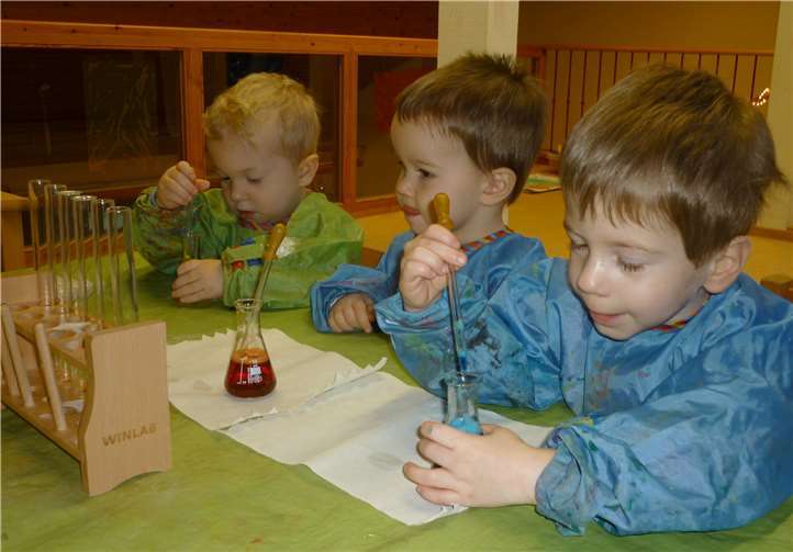 Die kleinen Forscher Felix Kroack, Aaron Bieler und Louis Wasem (von links) beim Experimentieren mit gefärbtem Wasser.Foto: Kita