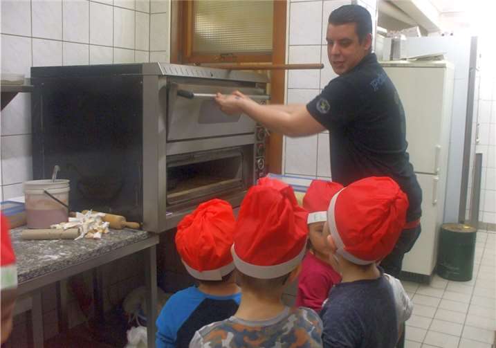 Die kleinen Pizza-Bäcker mit Profi Pieter Coralluzzo vor dem Pizza-Ofen.Stadt Meckenheim