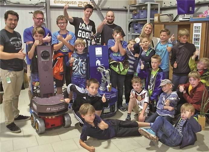 Die künftigen Robonauten zu Besuch beim Weltmeister: Diplom-Informatiker Viktor Seib (l.) von der Arbeitsgruppe Aktives Sehen der Universität Koblenz-Landau mit den begeisterten Besuchern und dem Roboter LISA (Mitte) von den technikcamps. privat