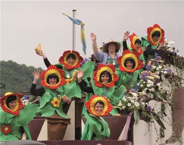 Die lebenden Sonnenblumen mit einer grandiosen Fröhlichkeit beim Blütenfestzug.