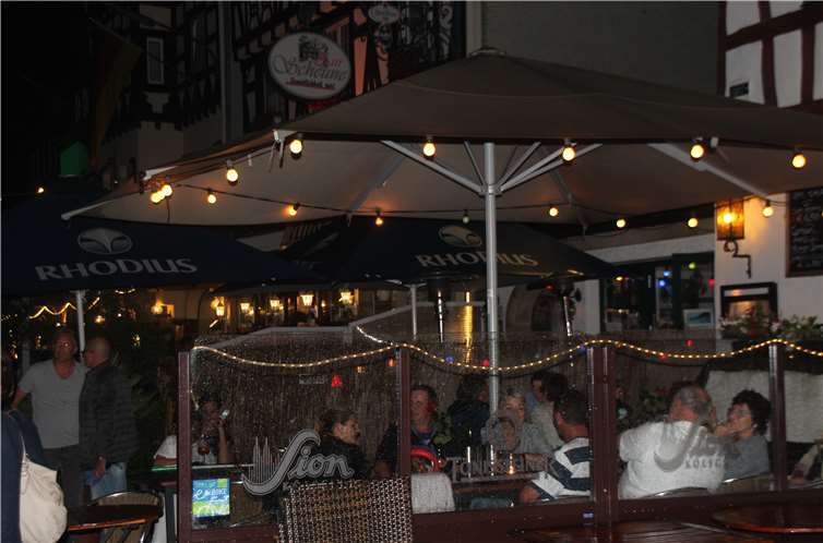 Die nächtliche Beleuchtung verleiht der Rheinpromenade eine besonders gemütliche Atmosphäre, die die Gäste gerne genießen.