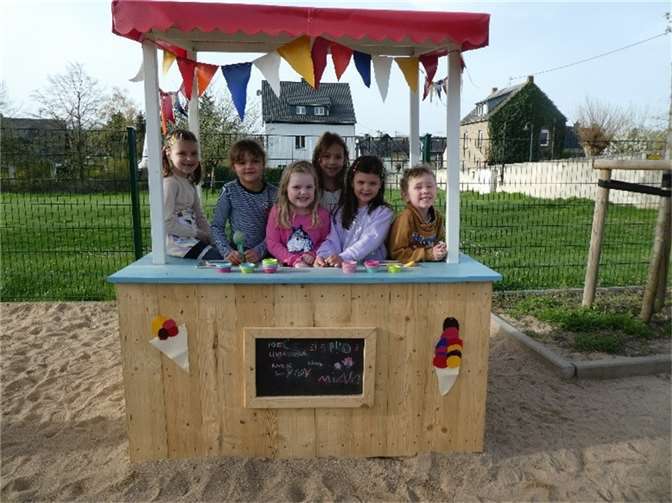 Die selbstgebaute Eisdiele aus Holz zusammen mit den Kindern der Igelgruppe der Kita St. Genovefa.