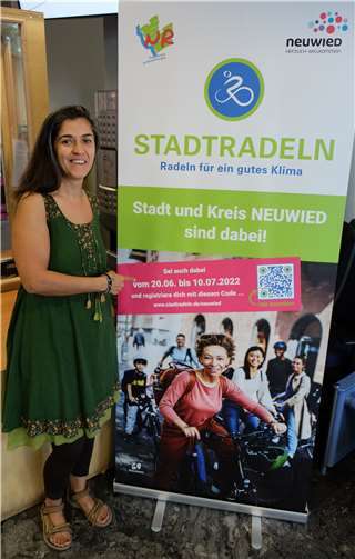 Die städtische Klimaschutzmanagerin Dr. Zuhal Gültekin vom Amt für Stadtmarketing vor dem Roll-up, das Besucherinnen und Besucher der Verwaltungsgebäude auf die Aktion Stadtradeln hinweist. Foto: Stadt Neuwied