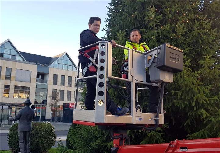 Die städtischen Mitarbeiter Christoph Iser (links) und Marco Schmidt (rechts) brachten an den Weihnachtsbäumen die festliche Beleuchtung an.