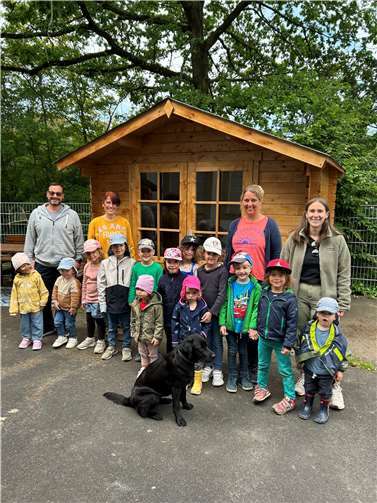Die stolzen Kinder zusammen mit Cristian Occhipinti, 1. Vorsitzende des Fördervereins (1. v.l.), Steffi Ems, Kita-Leitung (2. v.r.), und ihren Erzieherinnen von der neuen Holzhütte.  Foto: Eva Dreiser / Stadtverwaltung Lahnstein