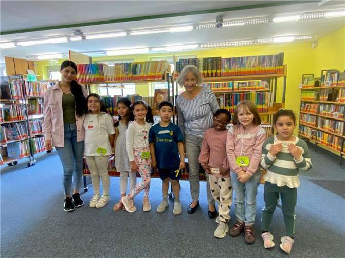 Die stolzen Leserinnen und Leser von morgen, hier gemeinsam mit ihrer Erzieherin und der Bücherbrücken-Mitarbeiterin Elisabeth Knauss (4.v.r.), können es kaum erwarten, die Regale der Bibliothek zu durchstöbern. Foto: Stadt Meckenheim