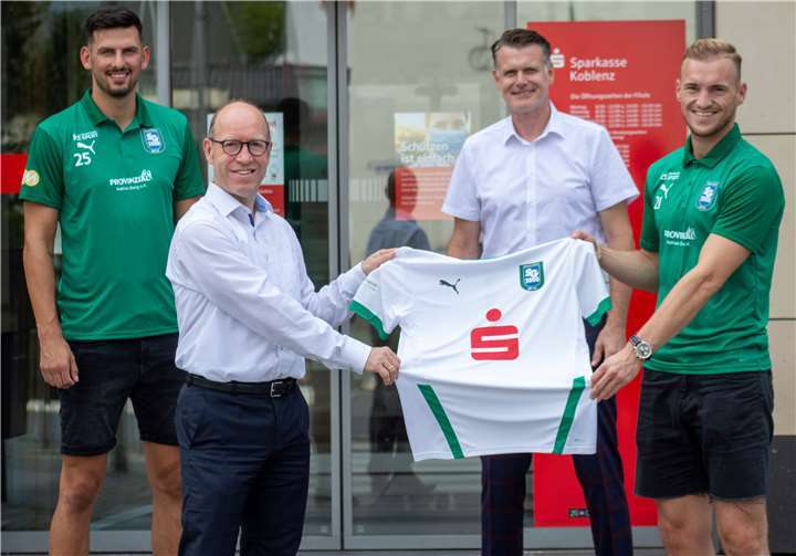 Die symbolische Trikotübergabe fand vor der Filiale in Mülheim-Kärlich statt. Hausherr Bernd Oster überreichte das symbolische Jersey an Daniel Dohmen, rechts hinten Jörg Karbach, Leiter Kommunikation der Sparkasse Koblenz und links SG Akteur Jan Henrich. Foto: privat