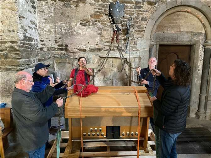 Die von der evangelischen Kirche in Sinzig gestiftete Orgel wurde mit einem Kran auf die Empore gehoben. Die Helfer KD Boden, Helmut Serf, Johannes Nickenig, Viktor Baum und Stiftungsgeschäftsführer Dr. Reinhard Lahr fassten tatkräftig an.. Foto: Stiftung Abtei Rommersdorf