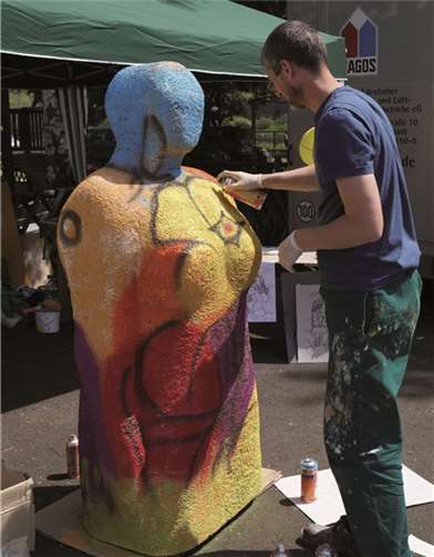 Dieser Künstler besprühte eine Figur mit bunten Farben.