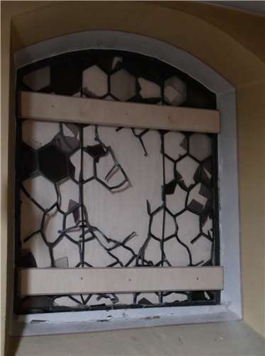 Dieses Fenster aus Bleiglas wurde mit zehn schweren Steinen beworfen, sodass es zerbrach.