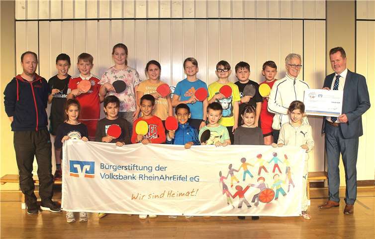 Dietmar Kalt, Leiter der Filiale Urmitz der Volksbank RheinAhrEifel (rechts), übergibt eine 350-Euro-Spende an die Ballsport AG der Grundschule Urmitz/Bahnhof mit Lehrerin Elisabeth Rech und Tischtennistrainer Dennis Johann (links).  Volksbank RheinAhrEifel