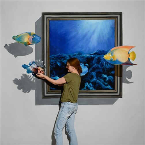 Direkt im Bild: Das 3D-Gemälde lässt Fische aus dem Rahmen treten und machen die Betrachter selbst zum Teil der Szene.  Foto: eli GmbH
