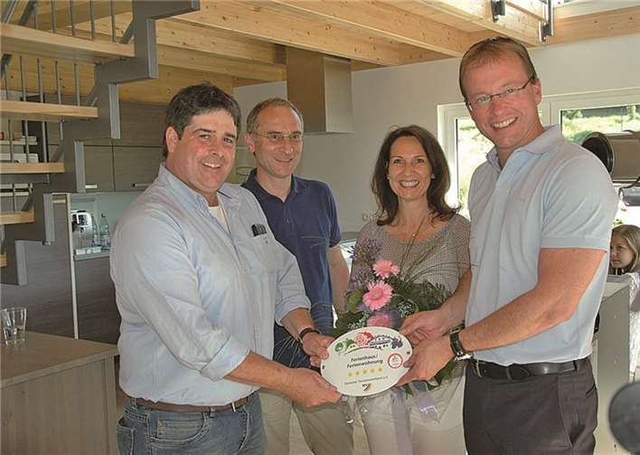 Dirk Fuchs (links) nahm die Plakette aus den Händen von Bürgermeister Jörg Lempertz (rechts) in Anwesenheit von Ortsbürgermeister Theo Krayer und seiner Ehefrau entgegen. privat