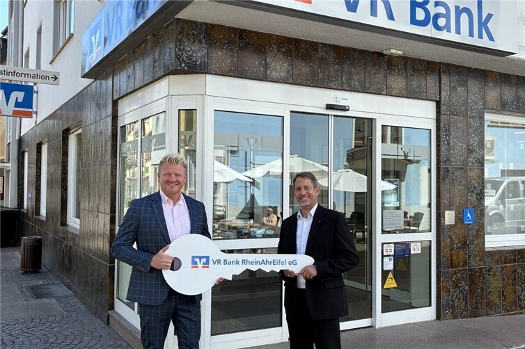 Dirk Hedrich (Teamleiter Privatkunden im Regionalmarkt AhrBrohltal) und Christoph Langenbach bei der symbolischen Schlüsselübergabe vor der Filiale der VR Bank RheinAhrEifel in Remagen.