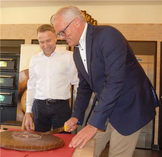 Dirk Hense beim Anschneiden des Spendentalers mit Helmut Moll.