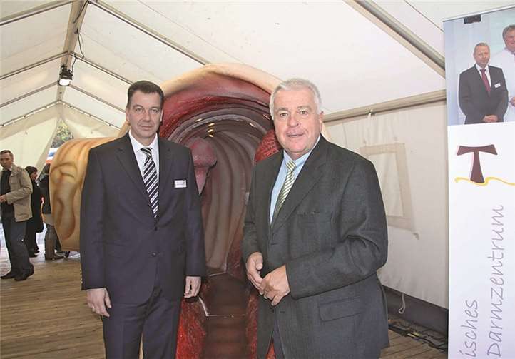 Dirk Rieck-Gangnus vom Krankenhaus Maria Stern und Guido Ernst, MdL (CDU) vor dem begehbaren Darmmodell.