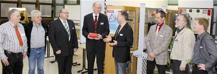 Dirk Waldecker (4. v. r.), Obermeister der KFZ-Innung überreicht die Messgeräte an Schulleiter Hans-Werner Rieck (5. v. r.). privat
