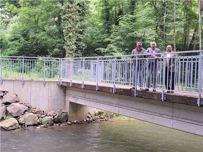 Dominik Dröschel, Bürgermeister Bernhard Mauel und Bürgermeister Alfred Schomisch am neuen Brückengeländer, das eine gefahrlose Querung der Rohr- und Fußgängerbrücke sichert. Foto: Matthias Steffens