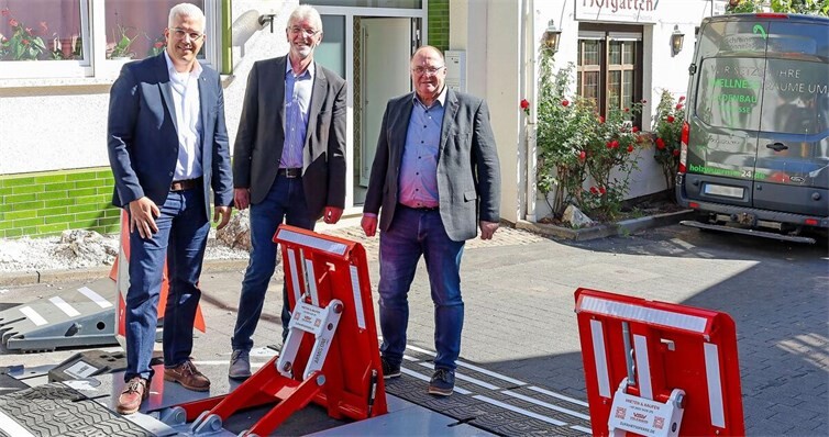 Dominik Gieler, Bürgermeister der Verbandsgemeinde Altenahr, Rolf Hans, Erster Beigeordneter der Verbandsgemeinde Brohltal, und Guido Nisius, Bürgermeister der Verbandsgemeinde Adenau, besichtigen in Dernau die gemeinsam beschafften Zufahrtssperren bei ihrem ersten Einsatz.