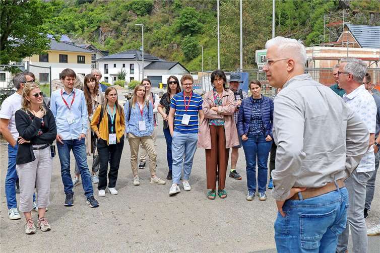 Nachhaltige Bauprojekte und Regenerationsfähigkeit der Natur im Fokus Dominik Gieler, Bürgermeister der Verbandsgemeinde Altenahr (vo. re.), begrüßte die Besuchergruppe des Klimabündnisses auf dem Schulgelände in Altenburg. Dort vermittelte er nachvollziehbar und mit vielen Beispielen die Situation des Wiederaufbaus und stand den Gästen für viele Rückfragen zur Verfügung. Foto: Thorsten Trütgen / VG Altenahr