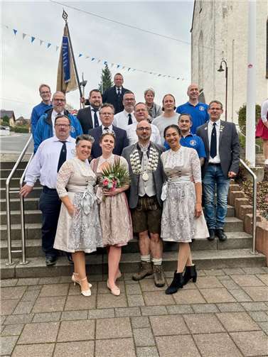 Dorfgemeinschaft mit Lederhose und Dirndl.