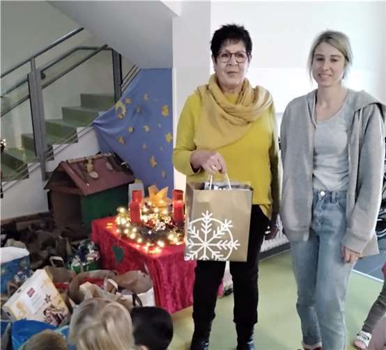 Doris Pütz vom Tafelteam und Linda Müller, pädagogische Fachkraft, mit den Kindern der KiTa St. Georg, Polch bei der Übergabe der Spenden. Foto: Dietmar Barth