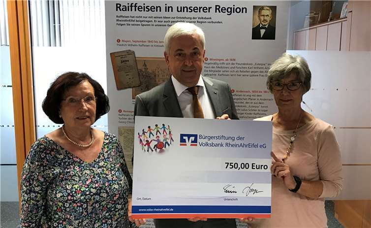 Dorothea Kalus (links), Vorsitzende des Krankenbesuchsdienstes und Monika Henn, ehrenamtliche Helferin, nehmen den Spendenscheck Karl Mohr, Direktor des Regionalmarktes MittelrheinMosel der Volksbank RheinAhrEifel eG, entgegen.privat