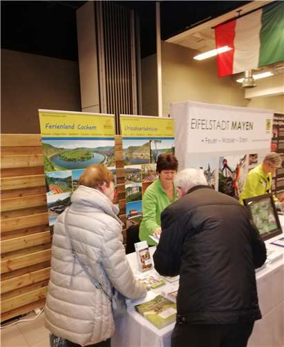 Dorothee Brachtendorf (Leiterin der Tourist-Information Treis-Karden) im Kundengespräch am Messestand.  Tourist-Information Treis-Karden
