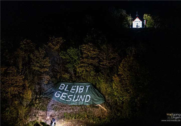 Dort wo sonst das Martinsfeuer loderte, erstrahlte nun der Schriftzug „Bleibt gesund“. Foto: Wolfgang Lingen